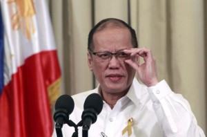 Philippines' President Benigno Aquino adjusts his eyeglasses while giving a nationwide televise statement on the Comprehensive Agreement on the proposed Bangsamoro Basic Law at the presidential palace in Manila