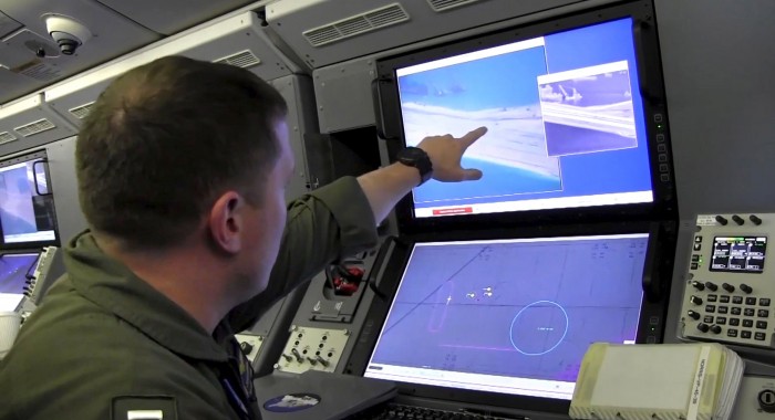 Still image from United States Navy video shows a U.S. Navy crewman aboard a surveillance aircraft viewing a computer screen purportedly showing Chinese construction on the reclaimed land of Fiery Cross Reef in the disputed Spratly Islands