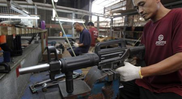 A former illegal gunsmith inspects a newly assembled multi-action shotgun at Shooters Arms, a gun manufacturing company exporting different kinds of weapons to other countries, in Cebu city