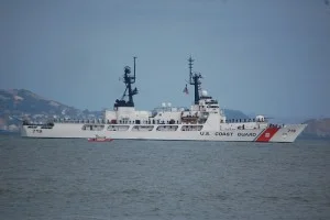 The USCGC Boutwell being escorted by a Coast Guart patrol boat.