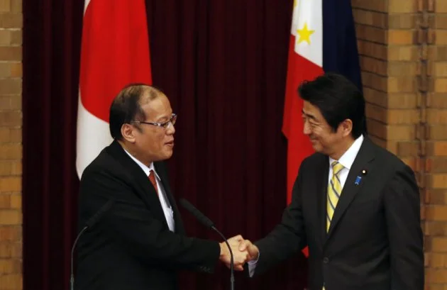Philippines' President Aquino shakes hands with Japan's Prime Minister Abe during a joint news conference at the prime minister's official residence in Tokyo