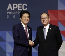 Japanese Prime Minister Shinzo Abe, left, is welcomed to the opening plenary session by President Benigno Aquino III at the Asia-Pacific Economic Cooperation (APEC) Summit in Manila, Philippines, (Mast Irham/Pool Photo via AP)